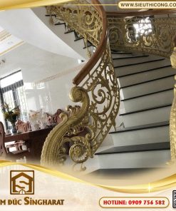 Mẫu cầu thang nhôm đúc uốn lượn ct35 nhũ vàng hoa lá tây tay vịn gỗ giếng trời Singharat
